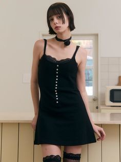 Woman in a black dress and thigh-high stockings with a choker in an indoor setting