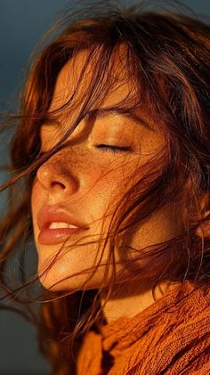 Close up of a woman with red hair and freckles in golden hour light