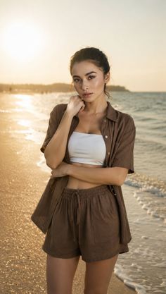 Woman in a white tube top and brown shorts on a beach at golden hour