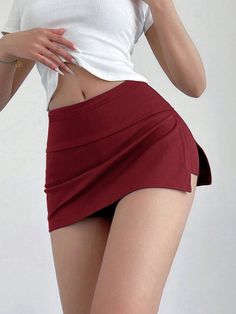 Woman in a red mini skirt and white crop top with exposed midriff