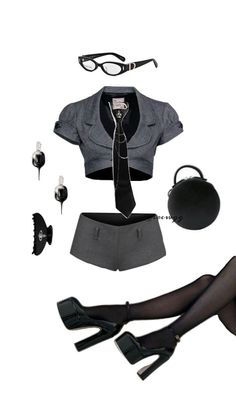 Flat lay of a gray cropped blazer, mini shorts, and black accessories