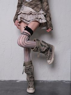 Person in a ruffled skirt, thigh-high socks, and boots posing indoors