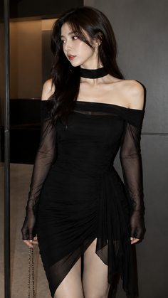 Woman in a black off-shoulder dress with sheer sleeves and a choker