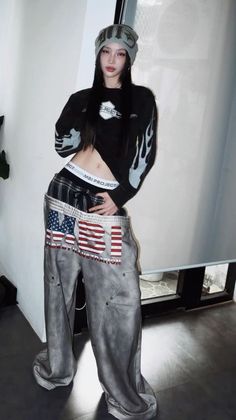 Woman in a beanie and baggy pants with exposed midriff indoors