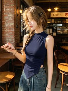Woman with a braid and denim jeans in a cafe, holding a phone