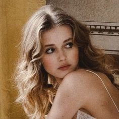 Woman with long wavy blonde hair looking over her shoulder