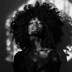 Woman with afro hair in dramatic black and white lighting