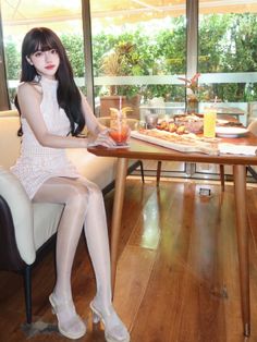 Woman in a lace dress and sheer pantyhose sitting at a restaurant table