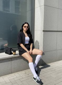 Woman with long black hair and sunglasses sitting outdoors