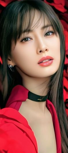 Woman with long black hair and a red top wearing a choker and earrings