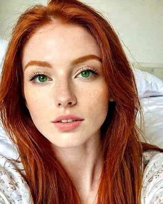Woman with red hair and green eyes looking directly at the camera