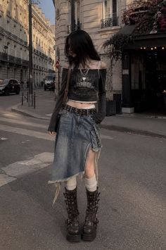 Person with long dark hair wearing a denim skirt and platform boots on a city street