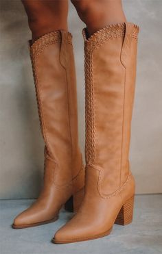 Pair of tan leather knee-high boots with decorative stitching and block heels