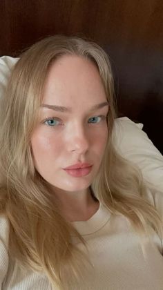 Woman with blonde hair and blue eyes in a soft-lit indoor portrait