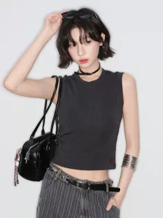 Woman with short black hair wearing a crop top and striped pants