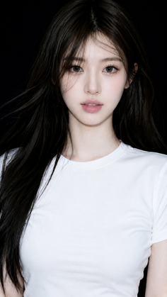 Woman with long black hair wearing a white t-shirt against a dark background