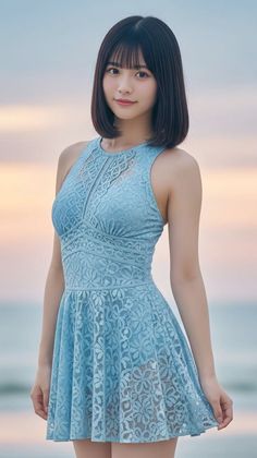 Woman in a blue lace dress with short hair outdoors at sunset
