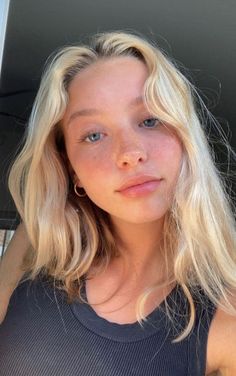 Close-up portrait of a young woman with blonde hair and blue eyes