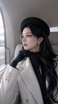 Woman with long black hair wearing a beret and white coat in a car