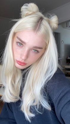 Woman with blonde hair in space buns and freckles looking at the camera