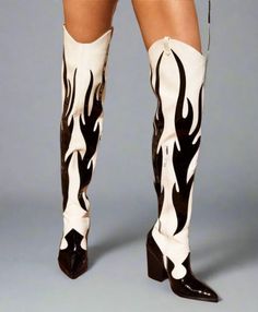 Person wearing thigh-high boots with a black and white flame pattern