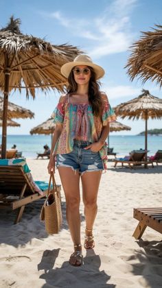 Woman in a colorful top and denim shorts walking on a sunny beach