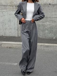 Woman in a gray suit with wide leg pants and a cropped blazer outdoors