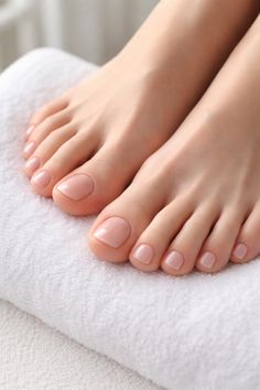Bare feet with a fresh pedicure resting on a white towel