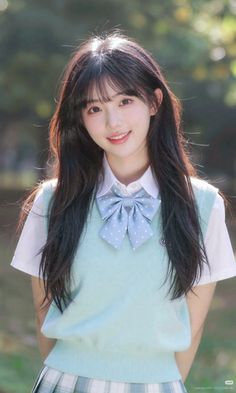 Young woman in a school uniform with a blue bow and plaid skirt outdoors