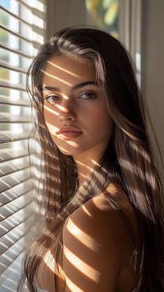 Woman with long hair and dramatic light stripes across her face and shoulder
