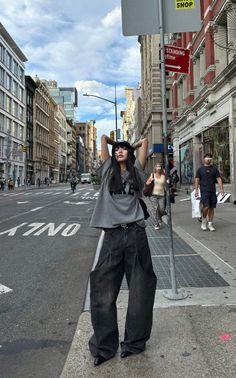 Woman in a bucket hat and baggy jeans posing on a city street