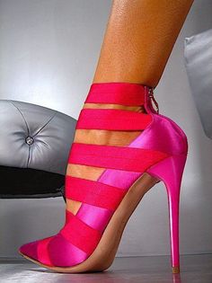 Close up of a foot wearing pink strappy high heels with a stiletto heel