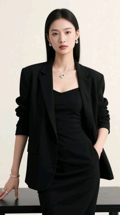 Woman in a black blazer and dress with jewelry in a studio shot