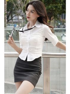 Woman in a white shirt and black mini skirt holding an ID badge outdoors