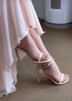 Woman's legs in sheer stockings and high heels with a light dress