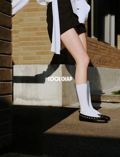 Person in black shorts and white shirt with exposed legs and white socks