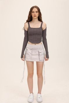 Woman with long hair wearing a crop top and mini skirt in a studio