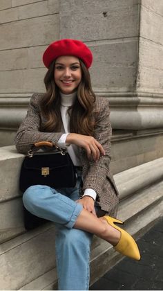 Woman in a red beret and plaid blazer sitting outdoors