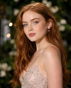 Woman with red hair and blue eyes wearing a beaded dress