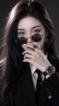 Woman in a pinstripe suit and sunglasses with long black hair