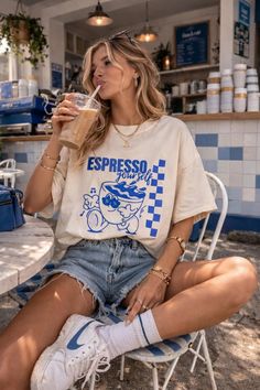 Woman with blonde hair drinking an iced coffee at an outdoor cafe