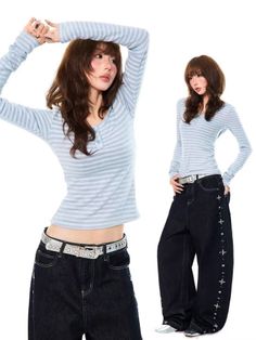 Woman in a striped shirt and baggy jeans posing against a white background