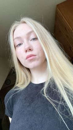 Young woman with long blonde hair wearing a black shirt indoors