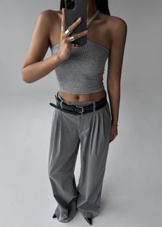 Person in a gray top and wide leg pants taking a mirror selfie
