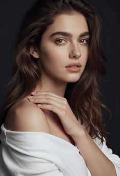 Woman with long brown hair and a white shirt draped off her shoulders
