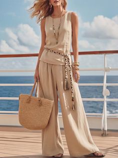 Woman in a beige outfit and straw bag on a cruise ship deck