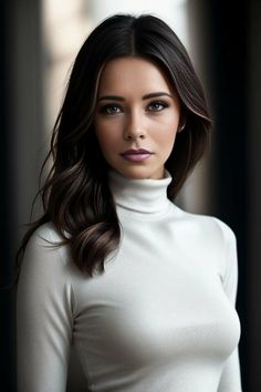 Woman with long dark hair wearing a white turtleneck, looking directly at the viewer