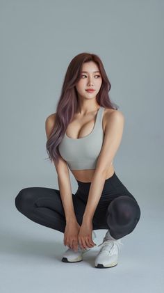 Woman in a sports bra and leggings squatting in a studio