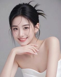 Woman with black hair in an updo, smiling with bare shoulders
