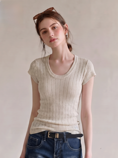 Woman with sunglasses on her head wearing a white top and blue jeans